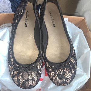 American Eagle Gold and black flats with lace details and a bow